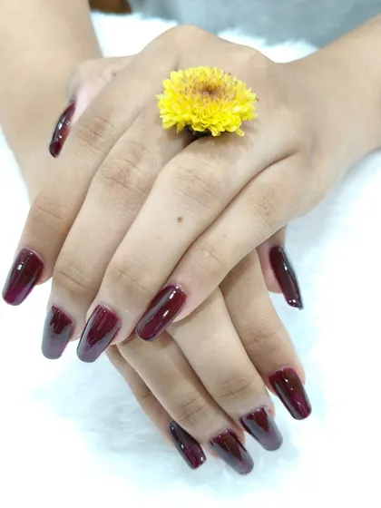 Another look at this elegant and bold wine-colored manicure. The coffin shape and high-gloss finish give it a luxurious feel that is perfect for any occasion.