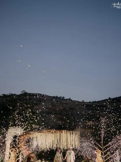 A magical moment captured as flowers rain down on the couple. This shot, with the mountain backdrop at dusk, perfectly encapsulates the romance of a destination wedding.