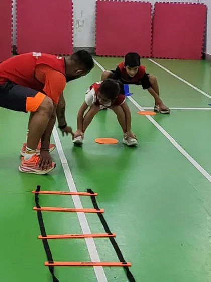 Here you can see our coaches giving personal attention during an agility ladder drill. We focus on correct form to build a strong foundation, ensuring every child learns safely and effectively. This is fundamental to our youth fitness games.