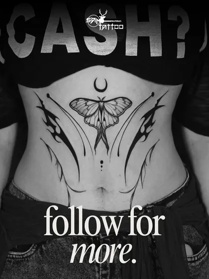 A beautifully symmetric stomach tattoo featuring a moth under a crescent moon, accented with fine-line and tribal elements.