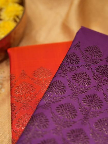 A close-up of two Kanjivarams in orange and purple with antique zari brocade, showcasing our festive range.