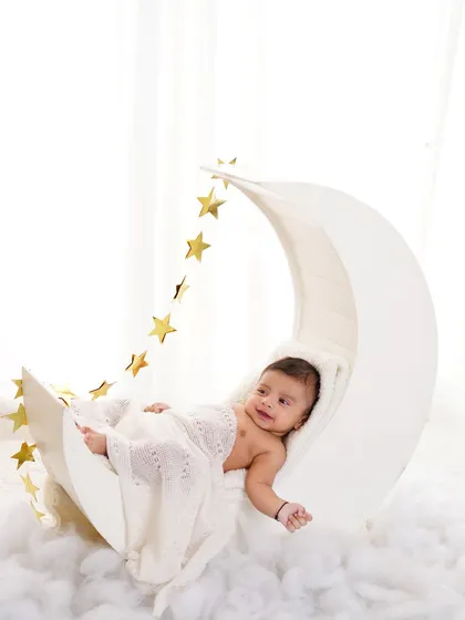 A six-month-old baby boy looking content and relaxed on our popular moon and stars prop. A perfect way to mark the half-year milestone.