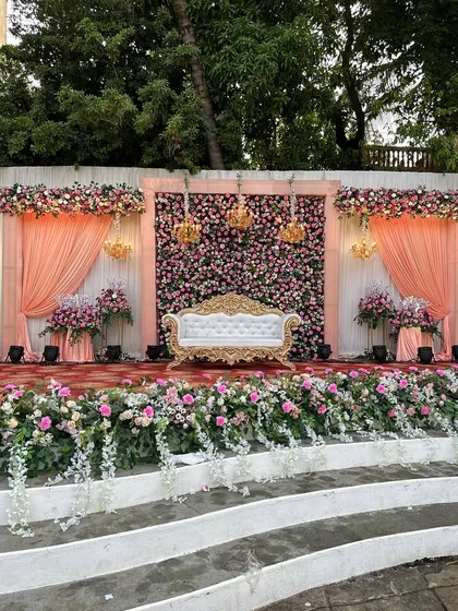 Another angle of the peach-themed reception stage, highlighting the ornate vintage sofa and the lush floral arrangements.