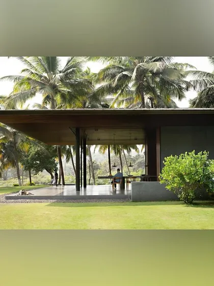 In this Alibaug project, the living space dissolves into the landscape. A covered pavilion with wide openings allows for uninterrupted views of the lawn and the surrounding grove of coconut palms.