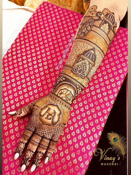 This full-arm back-of-hand design combines several of our signature elements. It features personalized initials, architectural jharokhas, and traditional motifs, perfect for a bride or a close family member.