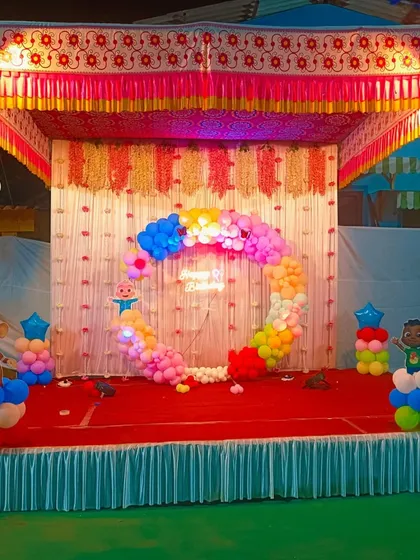 A Cocomelon-themed birthday setup on an outdoor or semi-outdoor stage.