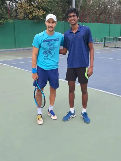 An on-court photo of our player Parth with ATP pro Tristan Boyer, an invaluable opportunity to learn from a professional.