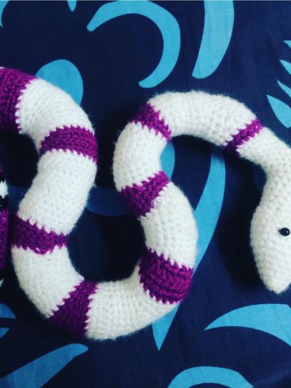 A full view of the custom-made purple and white striped crochet snake. It’s a great example of the unique and out-of-the-box requests I love to take on.