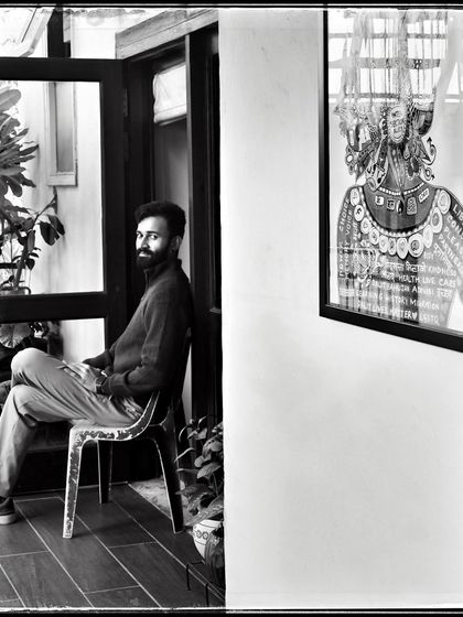 Tejas, seated in a doorway. The contrast between the bright outdoors and the darker interior creates a compelling frame for this portrait.