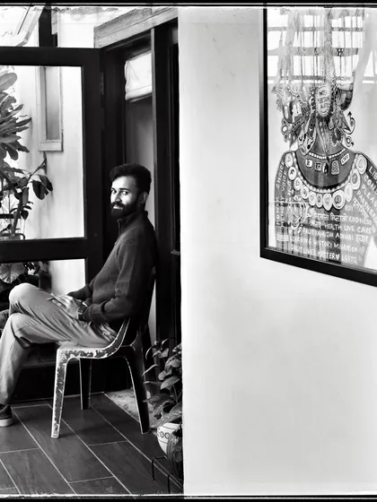 Tejas, seated in a doorway. The contrast between the bright outdoors and the darker interior creates a compelling frame for this portrait.