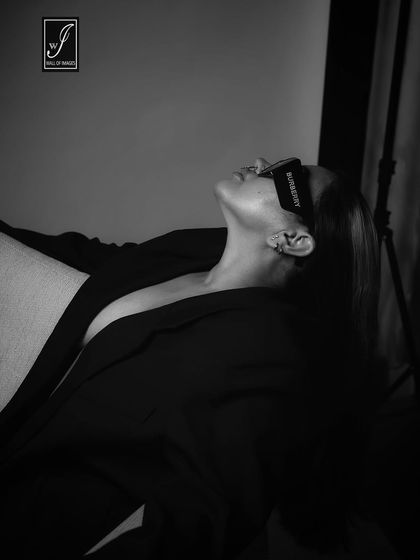 An artistic, high-contrast black and white shot that plays with shadows and highlights the model's profile.