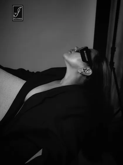An artistic, high-contrast black and white shot that plays with shadows and highlights the model's profile.