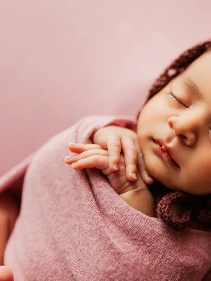 Another artistic close-up, this time showing the baby's profile and tiny hands.