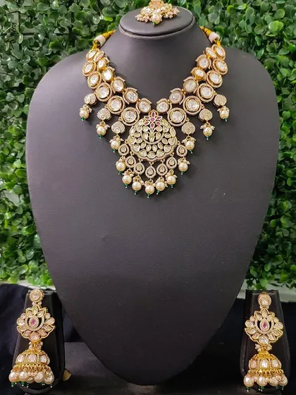 The full view of this elegant kundan and pearl set, showing the necklace, earrings, and maang tikka.