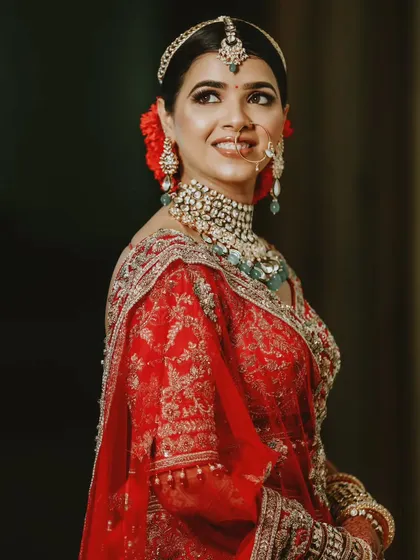 A classic bridal portrait showcasing the intricate details of the bride's jewelry and makeup. The soft lighting and her gentle smile create a look of pure elegance.