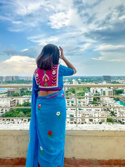A candid moment on the rooftop, with the wind in my hair. The colors of the blouse and saree pop against the cloudy sky.