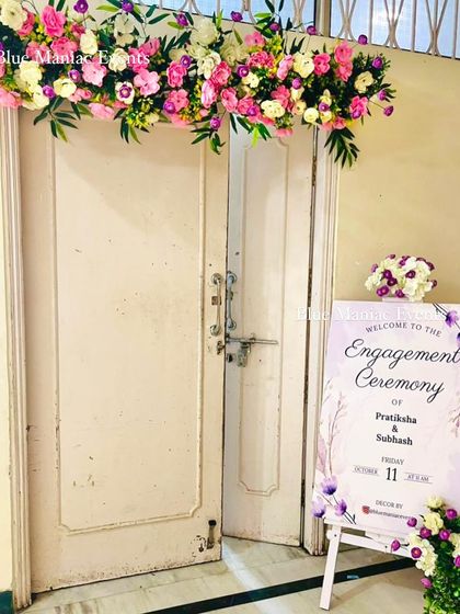 The entrance to an engagement ceremony at a temple, decorated with a floral runner and a personalized welcome sign. This shows my ability to create a welcoming ambiance from the very first step.