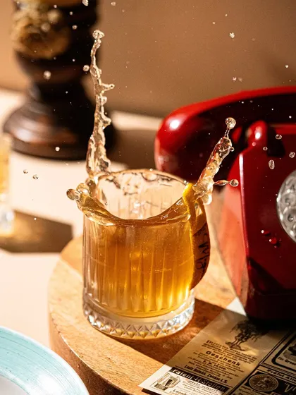 Capturing the splash. This dynamic action shot freezes a moment in time, adding energy and excitement to a simple whiskey on the rocks.