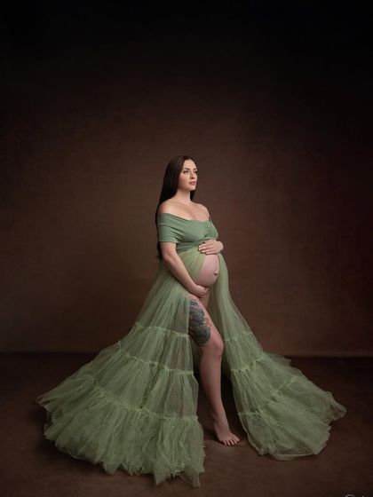 A classic pose in the olive tulle gown, looking off-camera. The earthy tones and soft fabric create a natural and elegant portrait.