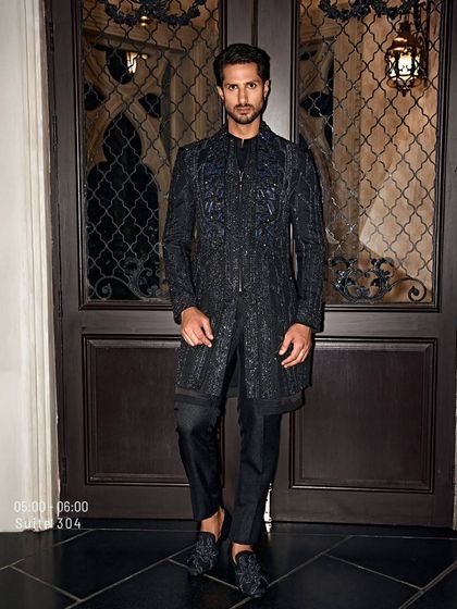 This black-on-black sherwani is a study in texture. The intricate, tonal embroidery creates a sense of depth and structure, a look of pure seduction for the man who appreciates fine detail.