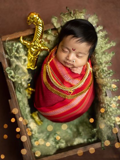 Another variation with the bokeh lights, this time from a higher angle, creating a dreamy and festive atmosphere around the sleeping baby.