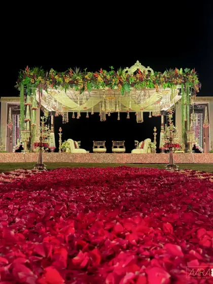 A surreal sunrise wedding overlooking the Bay of Bengal. The aisle, a river of red rose petals, leads to a mandap adorned with tropical flowers, creating a dramatic and unforgettable start to a new journey.