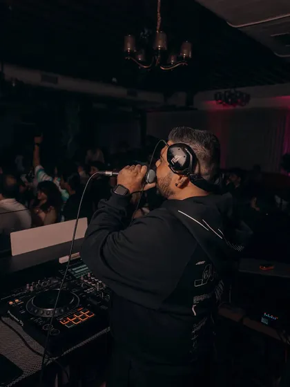 Hyping the crowd from the console. I'm the host, MC, and DJ all rolled into one, ensuring a non-stop party.