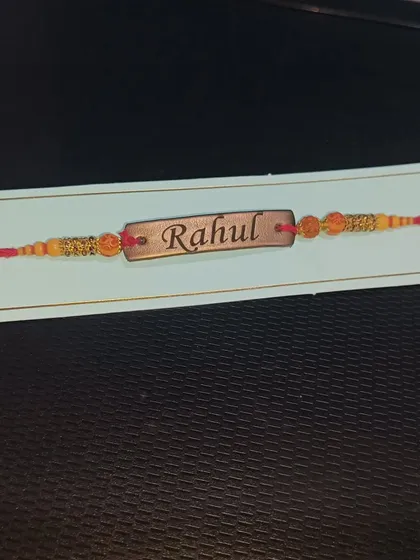 A close-up of my custom vegan leather Rakhi, engraved with the name 'Rahul'. A personal touch for your brother.