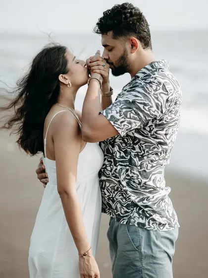 A gentle kiss on the hand is always a classic. This romantic gesture is captured up close during a beach photoshoot.