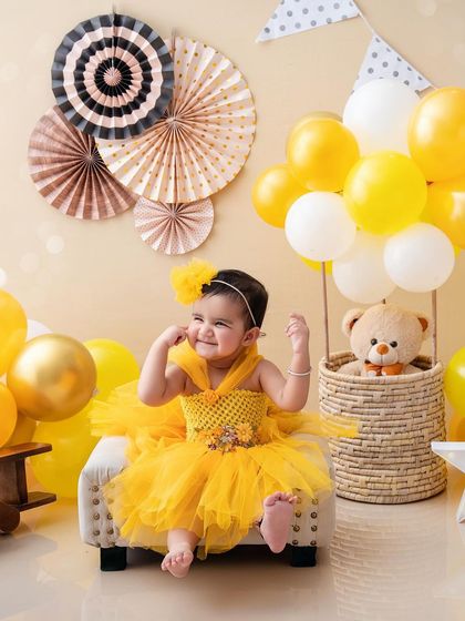 Double the trouble, double the fun. This twins photoshoot features a little girl in a bright yellow dress, ready for her hot air balloon adventure.