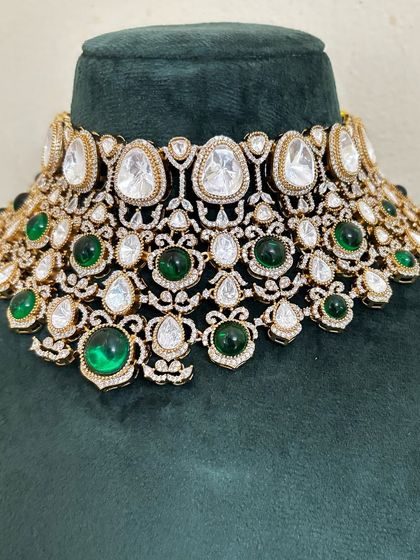 This choker necklace combines large Kundan stones with smaller green gems for a rich look. It's a versatile piece that can be rented for various festive occasions.