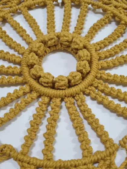 A close up of the center of the mandala, showing the detailed berry knots and radiating spokes. This level of detail is what makes handmade macrame so special.