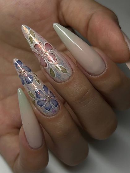 An incredibly detailed and artistic set of extra-long stiletto extensions. The design features delicate, stained-glass-effect flowers hand-painted on accent nails.
