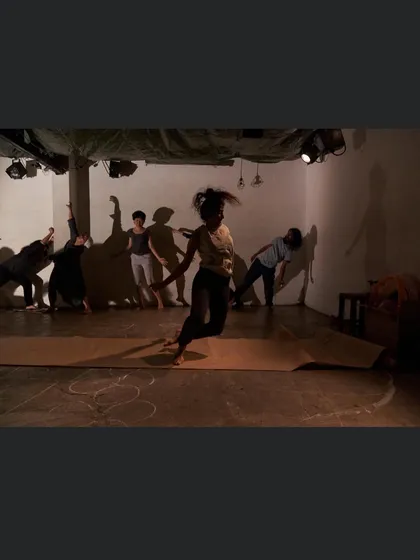 A powerful image of ensemble work from a theatre performance. The use of shadows and bodies creates a haunting and evocative stage picture.