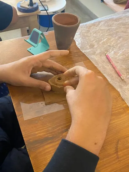 A student using a tool to add detail to their clay ear. Our workshops provide all the necessary sculpting tools to help you achieve realistic textures and forms.
