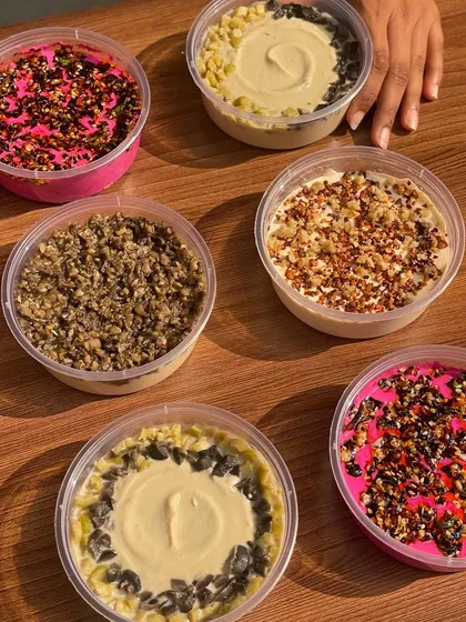 I offer a wide variety of handmade dips beyond just hummus. This image showcases an assortment of my creamy dips, each with unique toppings and flavour profiles.