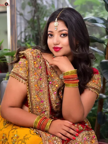 A classic seated portrait from a model portfolio session. The model's direct gaze and traditional attire are captured with soft lighting, creating a timeless and elegant image.