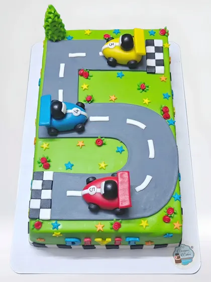 A car racing theme cake where the track forms the number 5. This rectangular cake is a fun and creative way to celebrate a 5th birthday for a little car enthusiast.