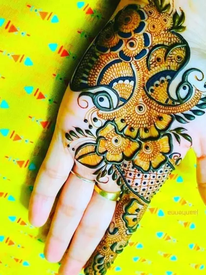 An intricate floral and paisley design that covers the back of the hand. The detailed shading and fine lines showcase a high level of artistry.