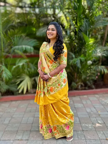 A full-length shot of the bride in her beautiful yellow saree for the Mahurat. The look is traditional, graceful, and full of sunshine.