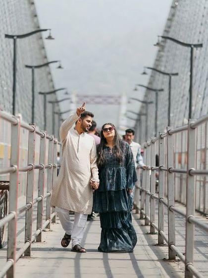A candid shot of the couple walking and talking on the bridge, capturing a natural interaction. This is what a real, unposed moment looks like.