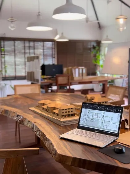 A view of my Goa studio, where a laptop with a floor plan sits next to a physical model. We use both digital and traditional tools to design and refine our projects.