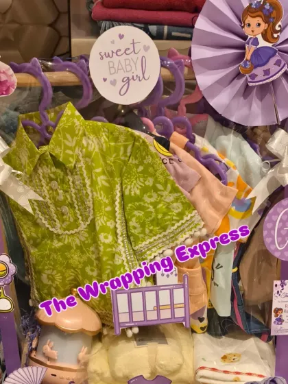 A princess-themed trousseau for a baby girl, with a beautiful green and white dress, decorated in purple with Sofia the First cutouts.