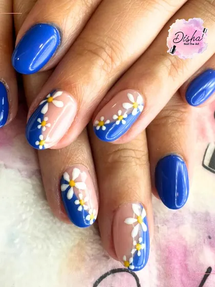 Feeling blue never looked so beautiful. This design pairs a bold royal blue with sheer accent nails featuring a cascade of hand-painted daisies.
