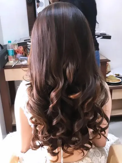 A simple yet elegant open hairstyle featuring well-defined, bouncy curls. This look focuses on creating volume and perfect texture for hair that looks great on camera.
