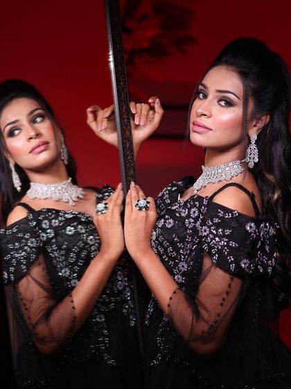 A close-up of the black ball gown, showing the beautiful contrast between the dark tulle and the sparkling silver embroidery, reflected in the mirror.