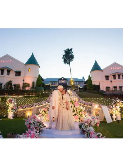 A classic portrait of the couple at their magnificent hill-station wedding. The grandeur of the venue at dusk, combined with the soft floral decor, creates a truly cinematic and unforgettable wedding photograph.