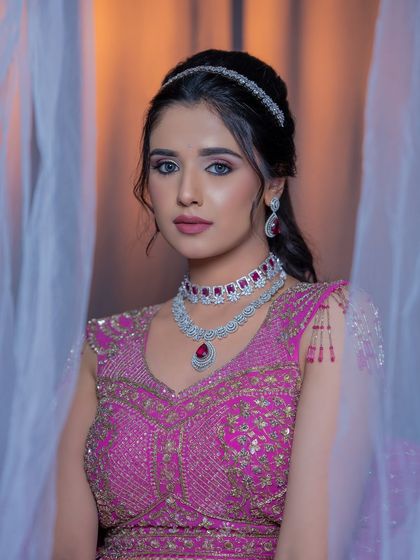 A close-up of the magenta lehenga look, focusing on the flawless base and eye makeup.