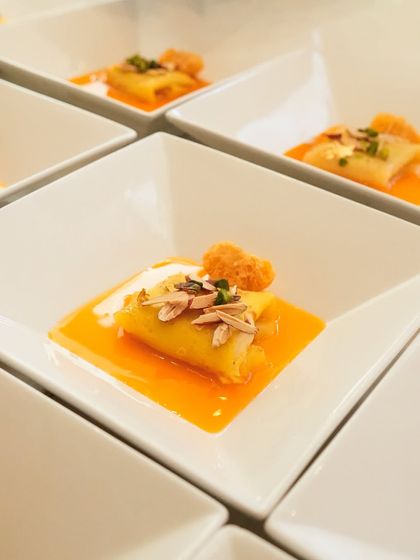 A close-up of our malpua, folded like a crepe and served in a bright citrus sauce. It’s a light yet satisfying end to a meal.