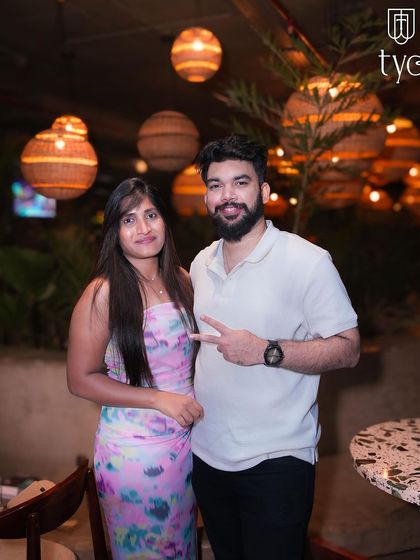A couple posing in the beautifully lit outdoor area of TYD.